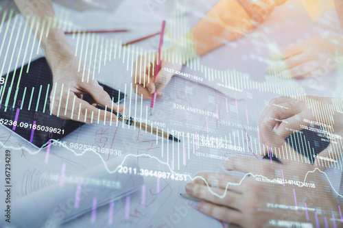 Double exposure of forex graph drawing and man and woman working together holding and using a mobile device. Trade concept.