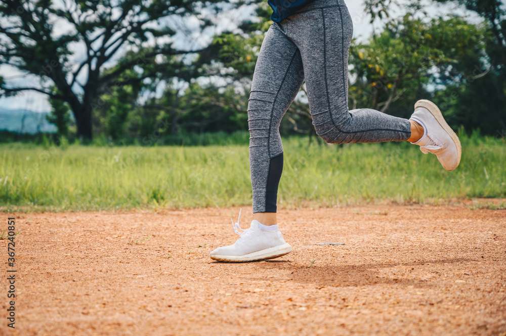 Woman doing workout by running on dirt road (or Trail running). The