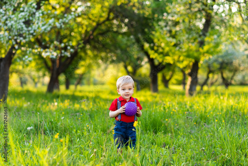 a boy stands in a clearing and plays with a ball a boy stands in a clearing and plays with a ball