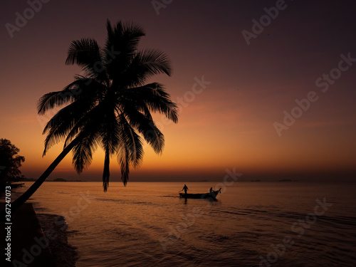 Silhouette of traditional Thai fishing boats with a background of the golden glow of sunrise © wrightouthere