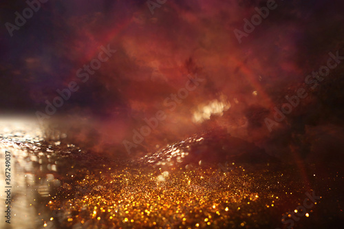 background of abstract red, gold and black glitter lights. defocused