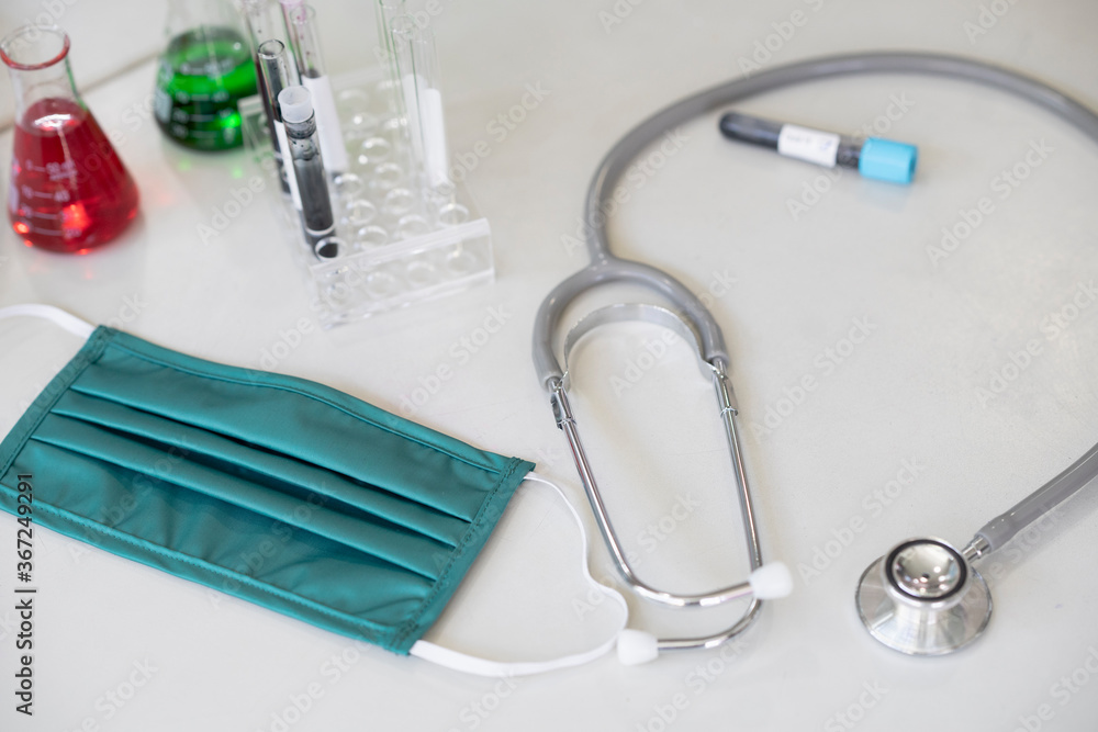 Doctor’s work space with Medical equipment, Stethoscope, Medical face mask, Vaccine, Covid-19 pandemic concept. Doctor’s work space with Medical equipment, Stethoscope, Medical face mask, Vaccine, Covid-19 pandemic concept.