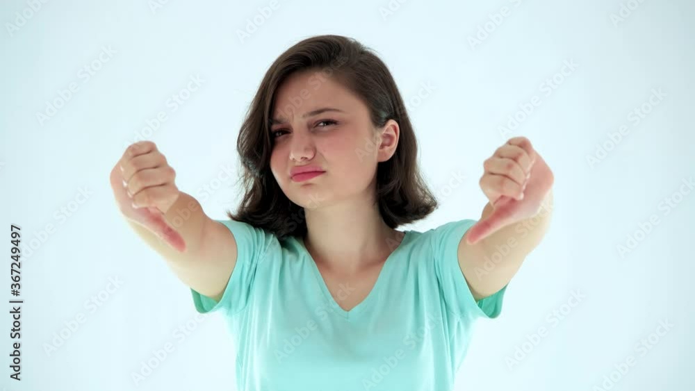Young attractive womand looking disapprovingly at camera and showing double thumbs down. Young attractive womand looking disapprovingly at camera and showing double thumbs down.