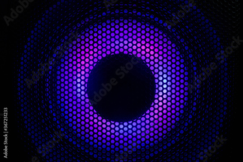 Close up photograph of a black speaker or sound system with purple led lighting.