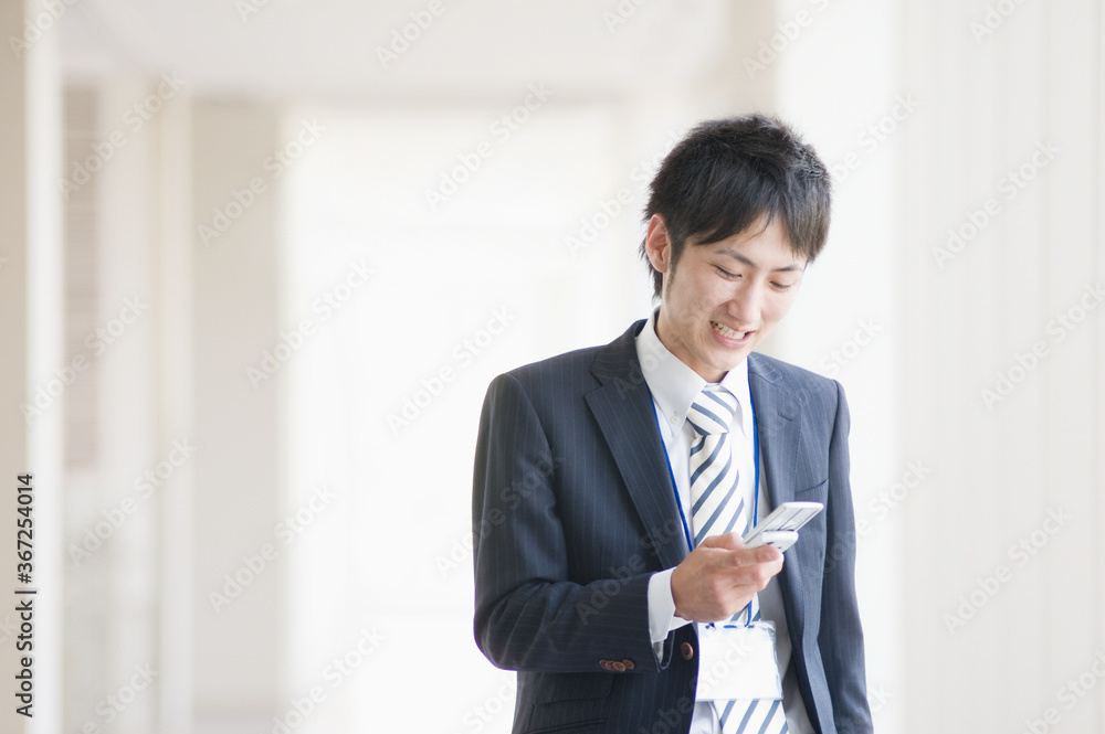 携帯電話を操作するビジネスマン