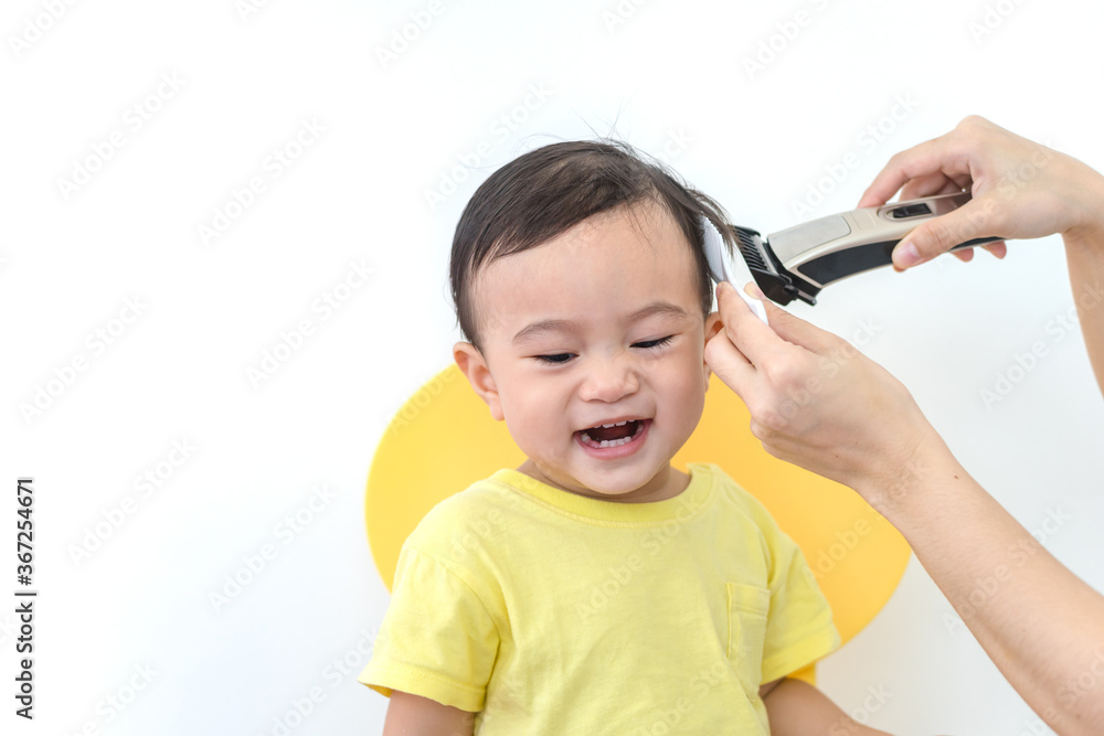 Asian happy baby getting his first haircut by mother during Covid-19 coronavirus pandemic, self-quarantine and social distancing. Asian happy baby getting his first haircut by mother during Covid-19 coronavirus pandemic, self-quarantine and social distancing.