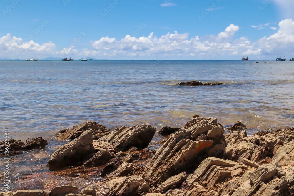 Rocks and boats at sea and blue skies