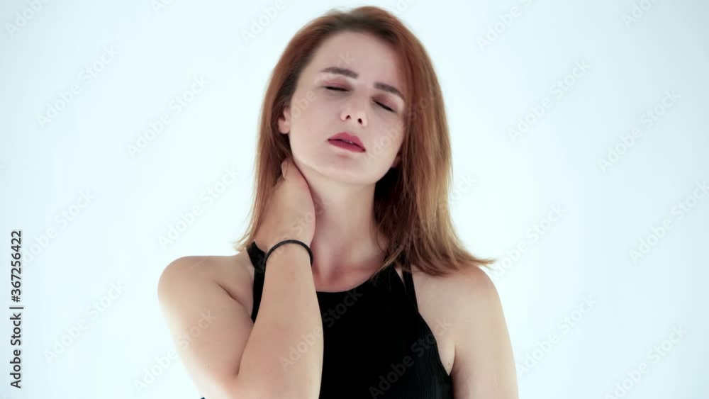 Portrait of tired young woman suffering from neckache and massaging neck isolated on white background. Studio shot. Concept of looking tired, overwork. Portrait of tired young woman suffering from neckache and massaging neck isolated on white background. Studio shot. Concept of looking tired, overwork.