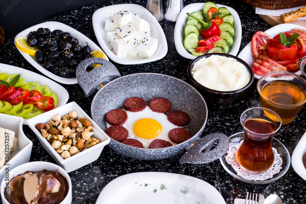 Traditional Turkish Breakfast with sausage egg pan on granite marble table.Close and large view Traditional Turkish Breakfast with sausage egg pan on granite marble table.Close and large view
