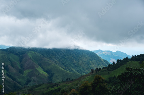 Landscape image of greenery rainforest mountains and hills on cloudy sky