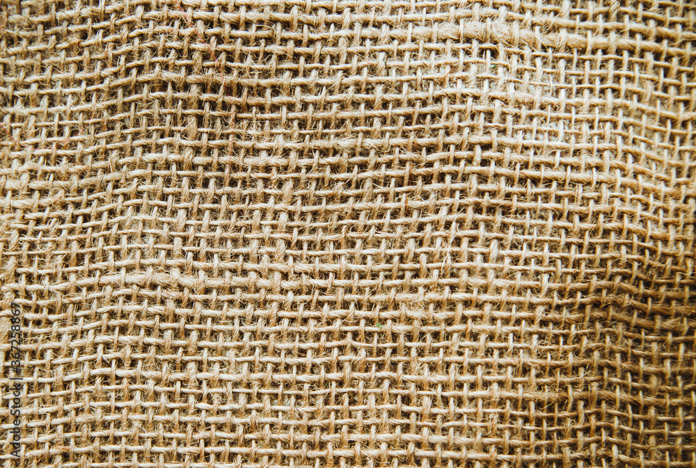 Burlap fabric, cotton fabric close-up beige and brown, with space for text.The texture of the fabric. Burlap fabric, cotton fabric close-up beige and brown, with space for text.The texture of the fabric.