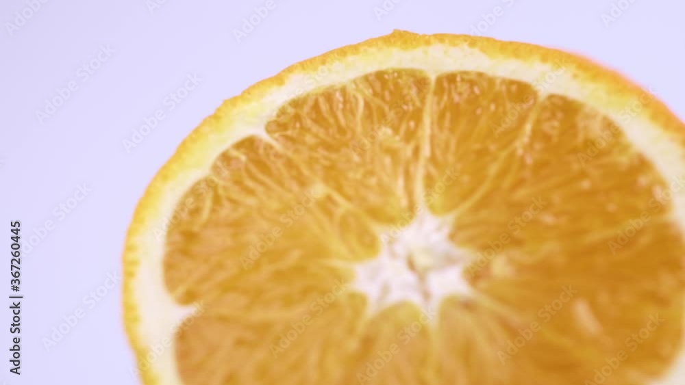 Close up fresh valencia orange sliced with white background shallow focus and slowly rotating. Close up fresh valencia orange sliced with white background shallow focus and slowly rotating.