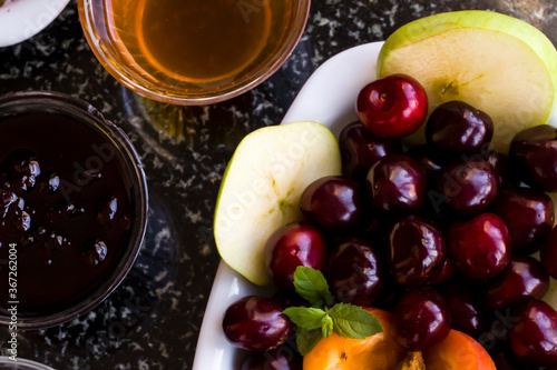 Detail shot of the breakfast table with fresh cherry jam and honey.