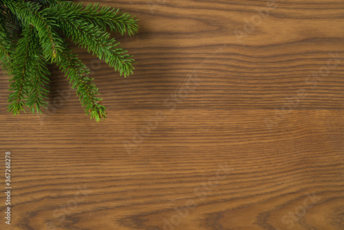 Flat lay christmas background with spruce twigs on ash wood surface