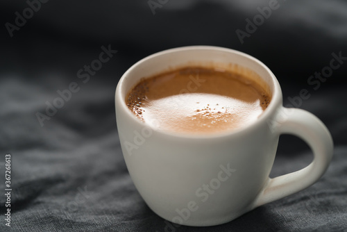 hot espresso in white cup on linen cloth with copy space
