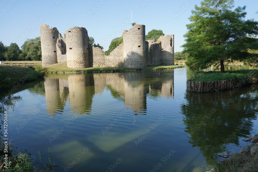 mirror reflection of an old stone fortress in the lake in France