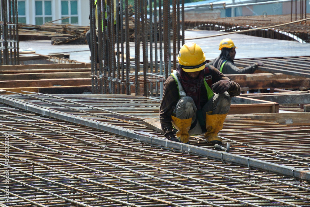 MALACCA, MALAYSIA -MAY 16, 2016: Construction workers fabricating steel reinforcement bar at the construction site in Malacca, Malaysia. The reinforcement bar was tied together using tiny wire.
MALACCA, MALAYSIA -MAY 16, 2016: Construction workers fabricating steel reinforcement bar at the construction site in Malacca, Malaysia. The reinforcement bar was tied together using tiny wire.