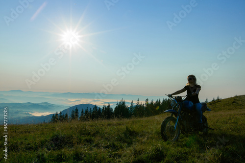 girl on a motorcycle travels in the mountains