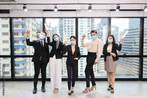 Group of cheerful business people from various sex including gay and LGBTQ wearing facial mask as new normal and social distancing policy implemented