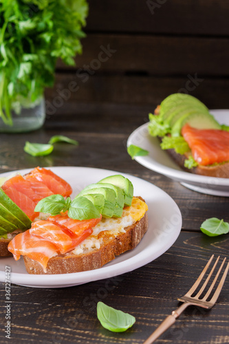 Different delicious sandwiches for breakfast, bread with cheese, avocado and trout, sandwich with egg and parsley with basil