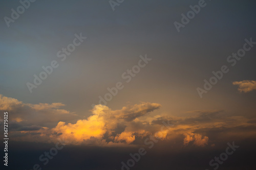 Clouds in the evening - yellow and orange sunset light lit cloud. Beautiful nature, landscape and cloudscape scenery. 