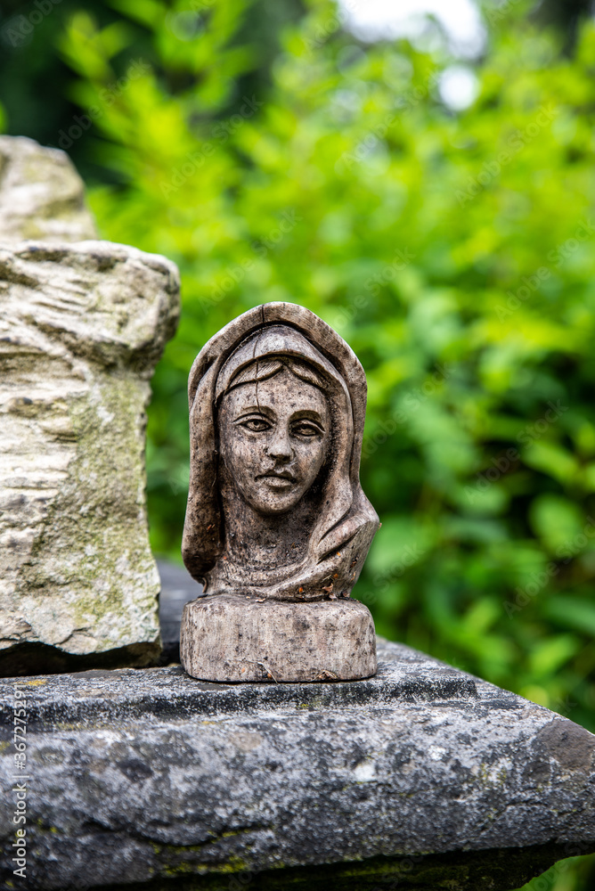 Geschnitzte Marienfigur auf einem Grabstein Geschnitzte Marienfigur auf einem Grabstein