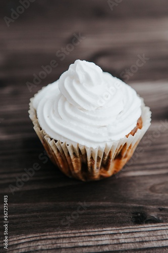 homemade muffins with white cream on a dark background