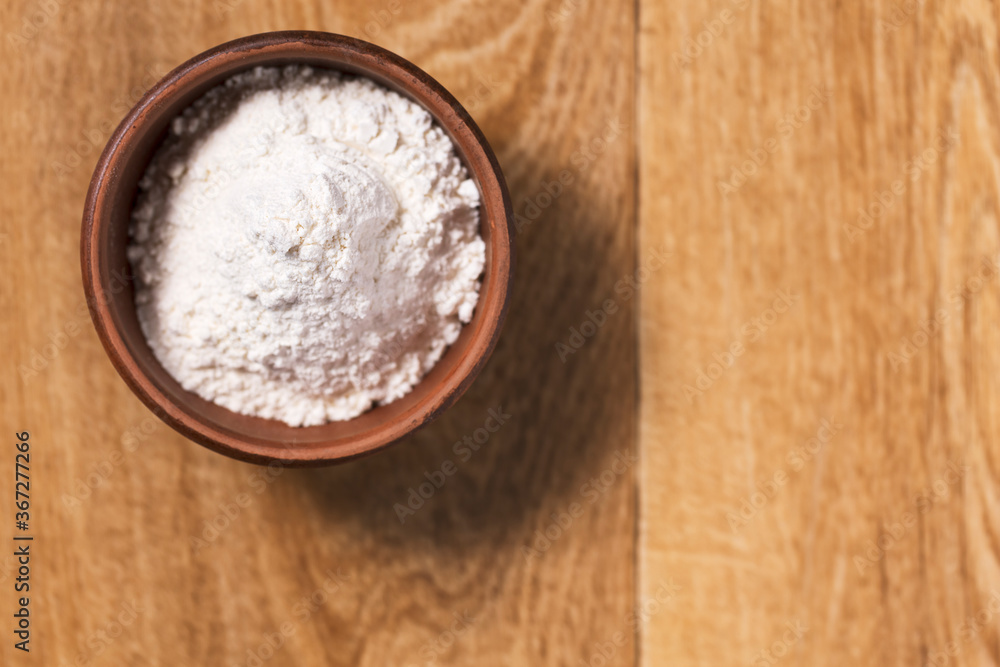 Bread flour in a bowl on a wooden table top view. Bread flour in a bowl on a wooden table top view.