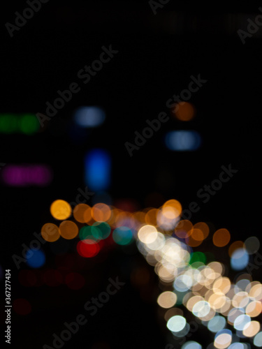 Abstract bokeh night light background, blurred lights traces from cars on road, defocused city traffic on street at night © Stella