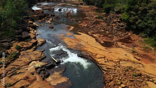 The river in the middle of the rocks towards the falls of Tad Tayicsua in Asia, in Laos, in Champasak, on the plateau of the Bolovens, on a sunny day. photo