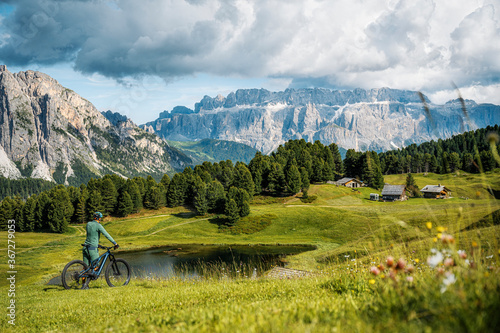 Schilderij op canvas Great panorama in the alps with mountain bike rider and huts