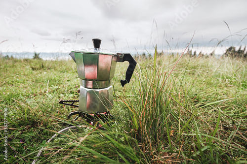 Brewing coffee in the moka pot at the outdoors camping in the mountains