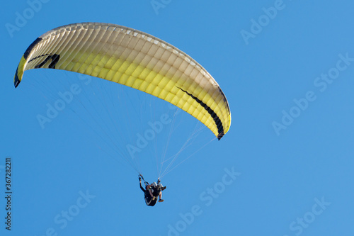 The wing of paraplan against a blue sky. Two paragliderists are flying in tandem. Copy space. photo
