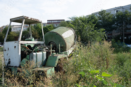 Hard equipment abandoned in the field and surrounded by grass in summer day 