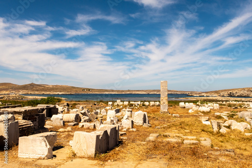 Ruins of an ancient city with stones, columns and temples on DELOS Island - mythological, historical, and archaeological site in Greece with blue sky background. photo
