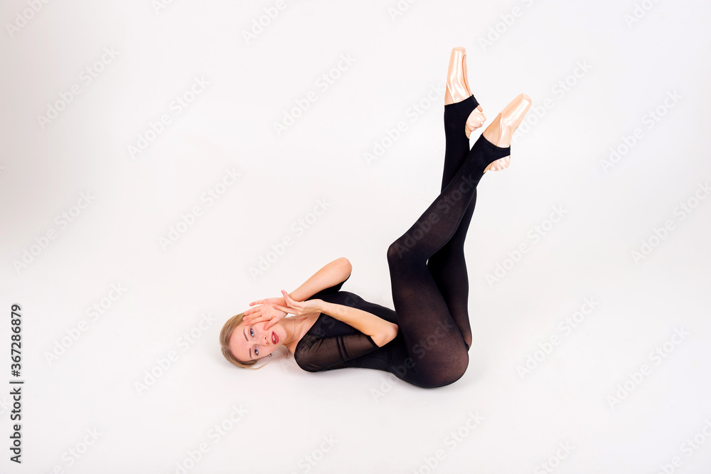 Portrait of slim young female gymnast with pale skintraining calilisthenics exercise on a white studio background