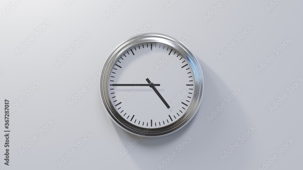 Glossy chrome clock on a white wall at quarter to five. Time is 04:45 or 16:45 Glossy chrome clock on a white wall at quarter to five. Time is 04:45 or 16:45