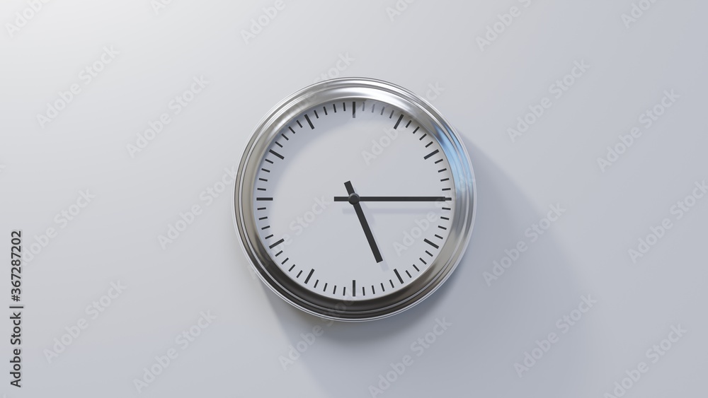 Glossy chrome clock on a white wall at quarter past five. Time is 05:15 or 17:15 Glossy chrome clock on a white wall at quarter past five. Time is 05:15 or 17:15