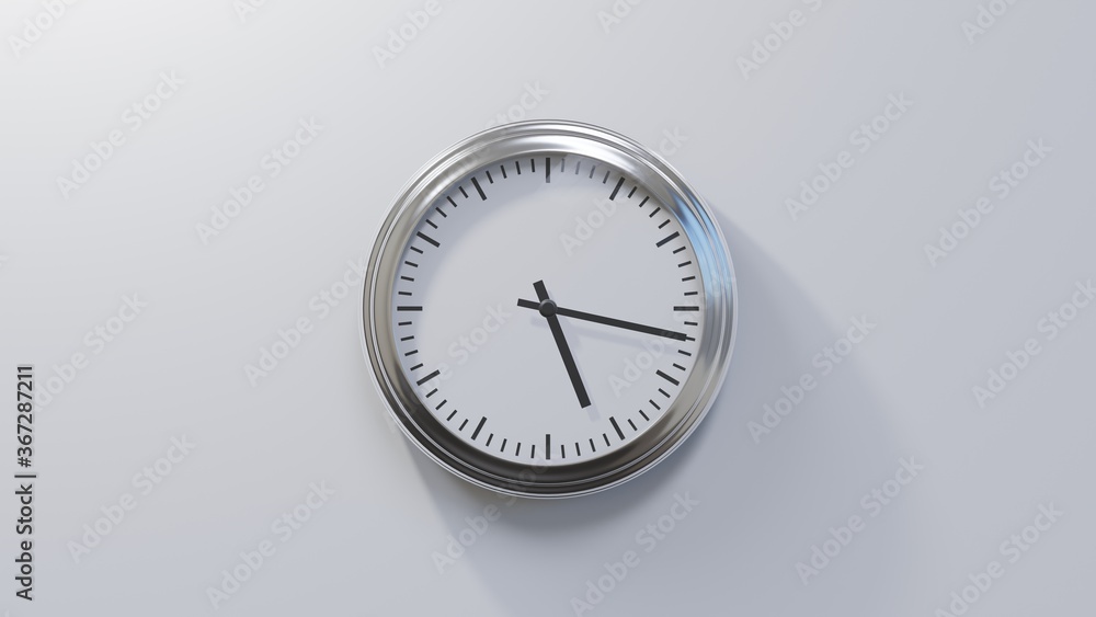 Glossy chrome clock on a white wall at seventeen past five. Time is 05:17 or 17:17 Glossy chrome clock on a white wall at seventeen past five. Time is 05:17 or 17:17