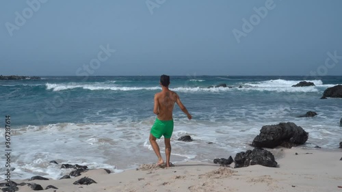 Hombre joven juega en la orilla de la playa. Orzola. Lanzarote. Las Palmas . Islas Canarias photo