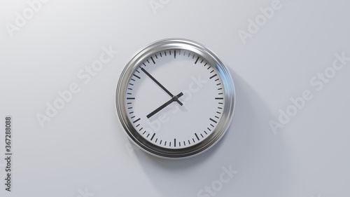 Glossy chrome clock on a white wall at fifty-two past seven. Time is 07:52 or 19:52
