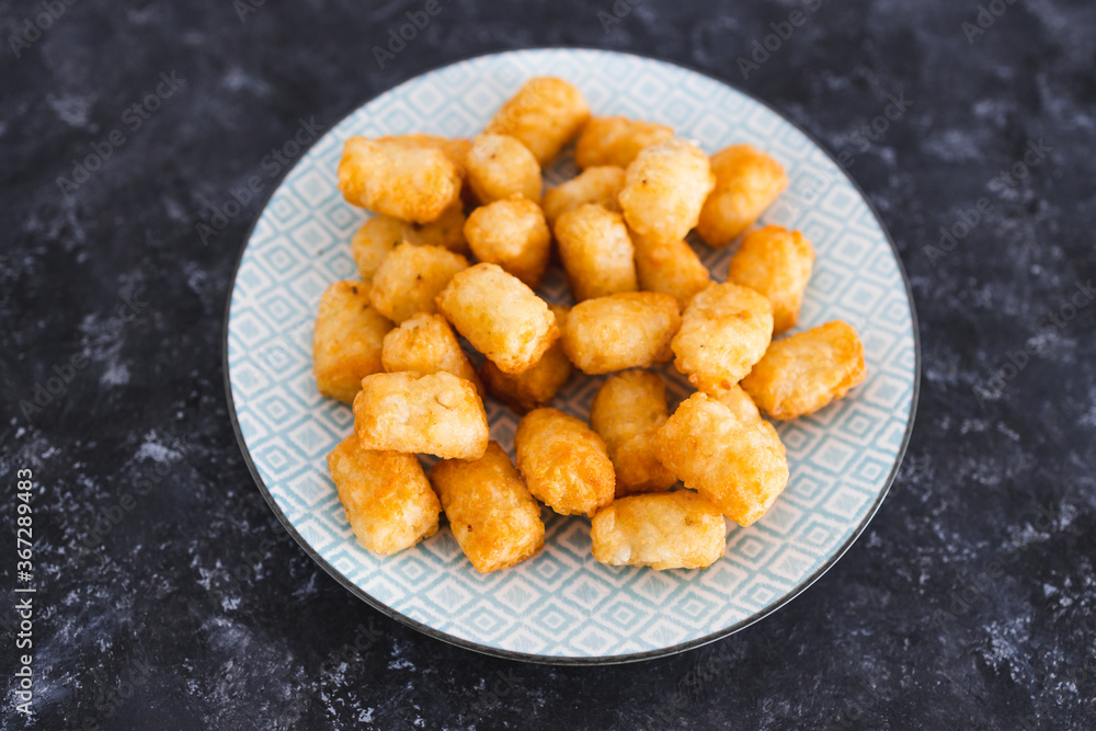 simple food ingredients, air fryed potato royals on small snack plate on dark background simple food ingredients, air fryed potato royals on small snack plate on dark background