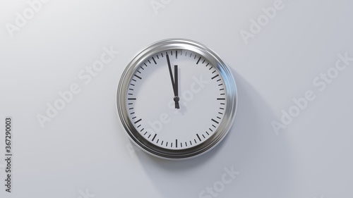 Glossy chrome clock on a white wall at fifty-eight past eleven. Time is 11:58 or 23:58