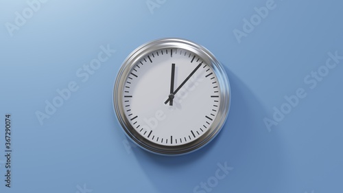 Glossy chrome clock on a blue wall at seven past twelve. Time is 00:07 or 12:07