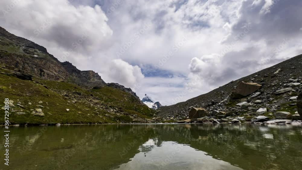 Serene Water At The Small Alpine Lake With A Cloudy Sky In Zermatt, Switzerland, Europe At Daytime - timelapse Serene Water At The Small Alpine Lake With A Cloudy Sky In Zermatt, Switzerland, Europe At Daytime - timelapse