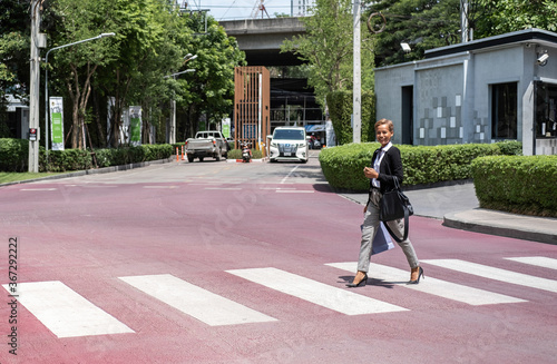 Young business woman crossing the street at the modern office district stock photo