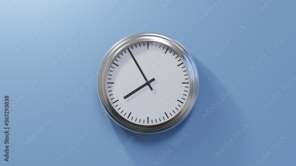 Glossy chrome clock on a blue wall at five to eight. Time is 07:55 or 19:55
