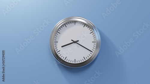 Glossy chrome clock on a blue wall at twenty past eight. Time is 08:20 or 20:20