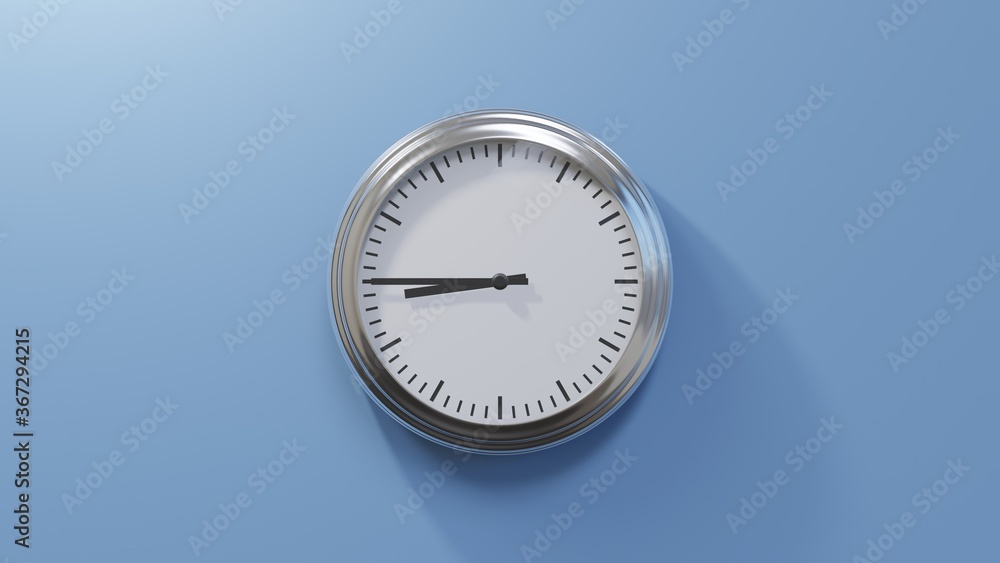Glossy chrome clock on a blue wall at quarter to nine. Time is 08:45 or 20:45 Glossy chrome clock on a blue wall at quarter to nine. Time is 08:45 or 20:45