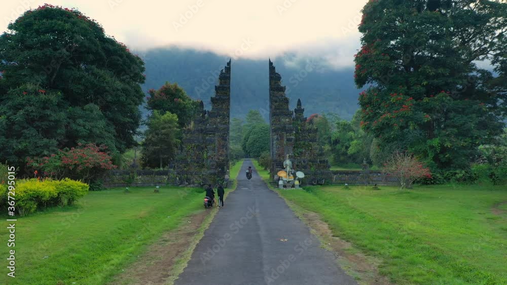 Epic aerial flight through traditional hindu Gate on background scenery mountain in fog. Bali is a famous destination for its breathtaking nature and culture. 4K Epic aerial flight through traditional hindu Gate on background scenery mountain in fog. Bali is a famous destination for its breathtaking nature and culture. 4K
